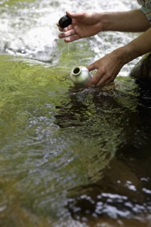 A man with a reusable water bottle in the woods