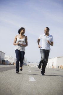 A couple running on road outdoors
