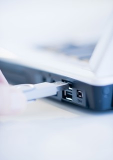 A hand plugging in a universal serial bus.