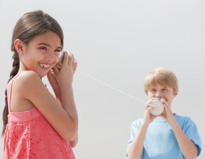 Children playing with a tin can telephone.