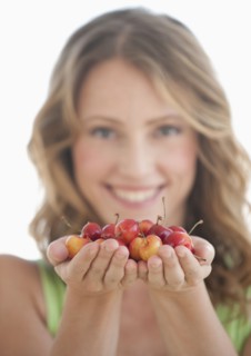A woman holding cherries.