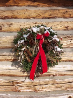 A Christmas wreath on a cabin wall