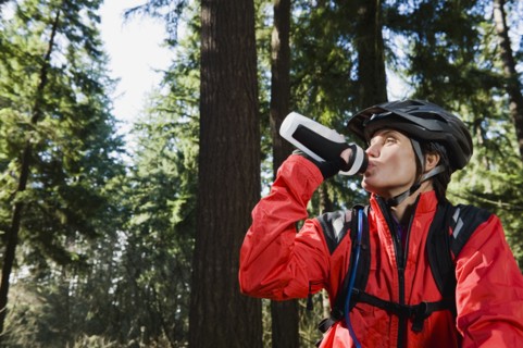 Biker in the woods drinking water
