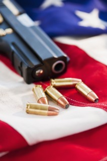 A handgun and ammunition on the American flag