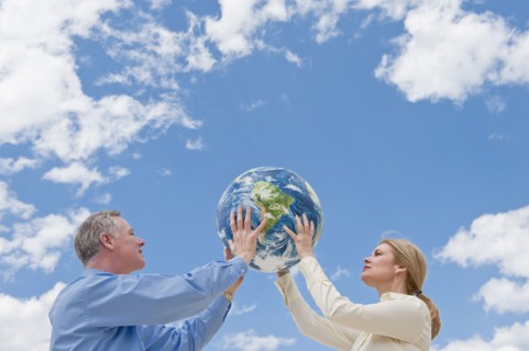 Two people holding up a globe.