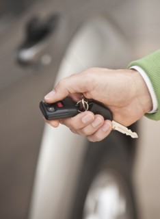 A hand holding a car remote key.