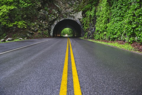 A scenic and empty road with tunnel.