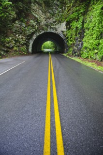 A scenic and empty road with tunnel.