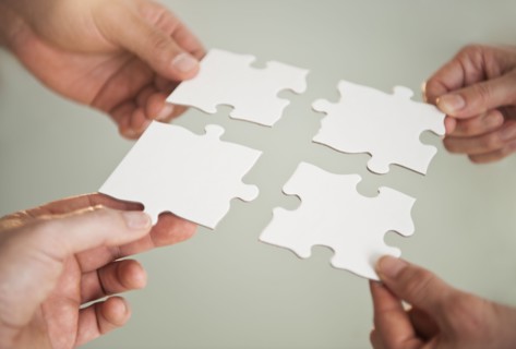 Hands holding puzzle pieces.