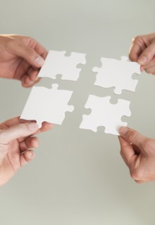 Hands holding puzzle pieces.