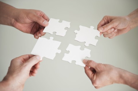 Hands holding puzzle pieces.