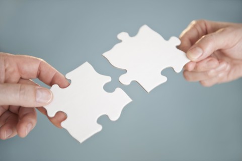 Hands holding puzzle pieces.
