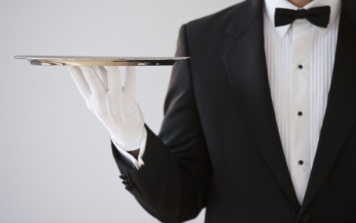 A server holding a silver tray.