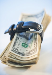 A watch around a stack of money.