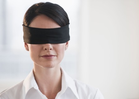 Businesswoman wearing blindfold.