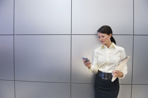 A businesswoman using a personal digital assistant.
