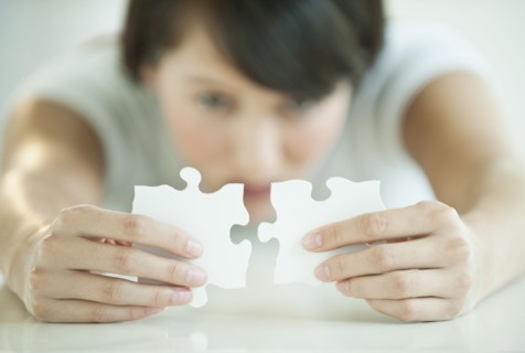 Woman holding puzzle pieces.