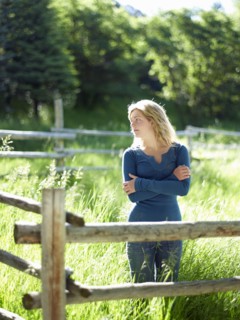Young woman behind fence