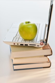 Apple on laptop and books.