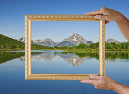 Picture frame held up to scenic view.
