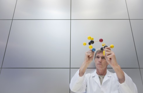 Reseacher holding molecular model.