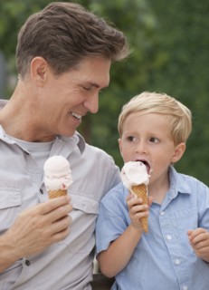 Father and child eating ice cream cones.