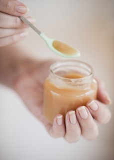 Hand spooning baby food.