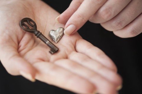Hands holding heart and key.