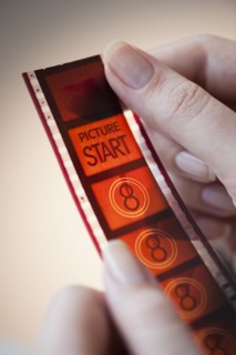 hands holding film strip.