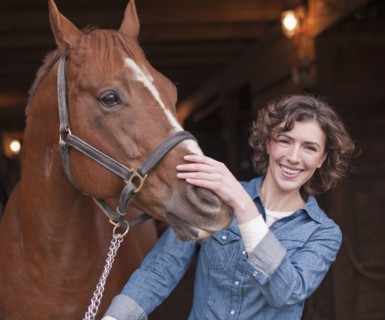 Woman holding horse.