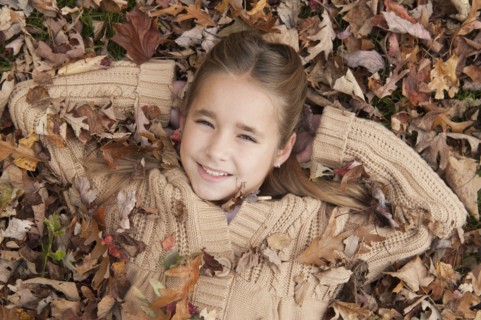 Girl lying in leaves.