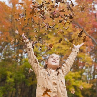 Girl throwing leaves.