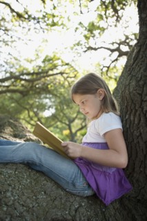 Girl reading book in tree