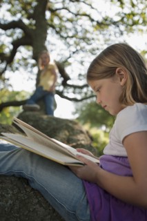 Girl reading book in tree