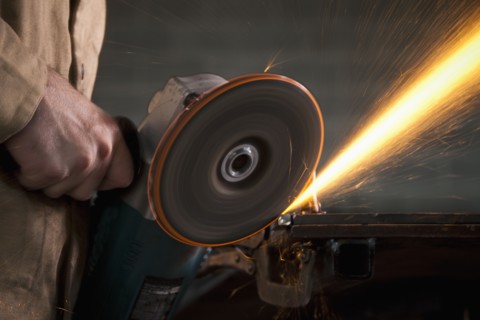 Steel grinder working in metal shop