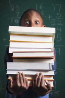 Boy holding stack of books