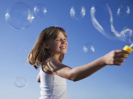 Young girl playing with bubbles
