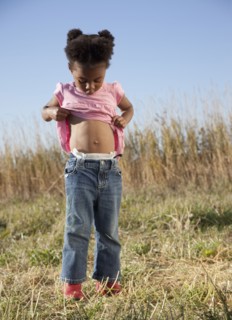 Young girl looking at her belly button