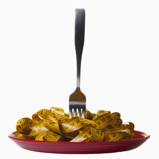 Measuring tape and fork on plate