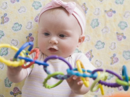 Portrait of baby girl playing with toy