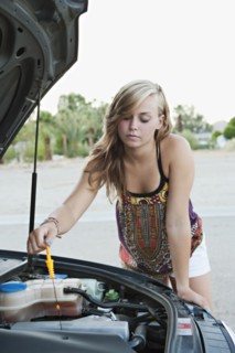 Woman checking car's oil