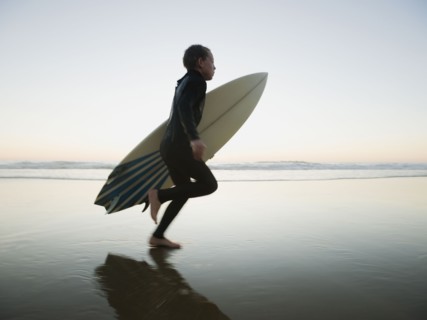 Child running with surfboard