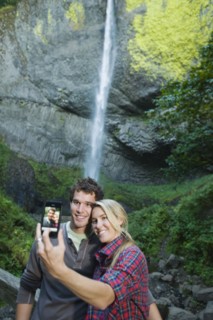 Couple taking picture in front of waterfall