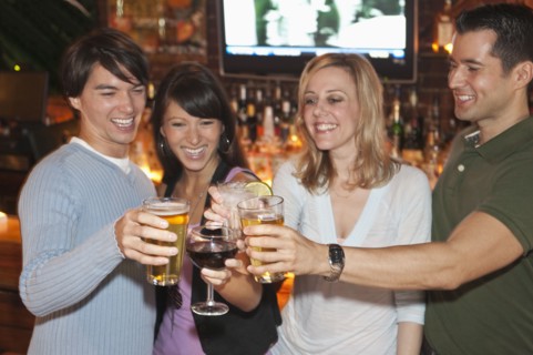 Friends toasting at bar.