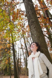 Woman leaning on tree.
