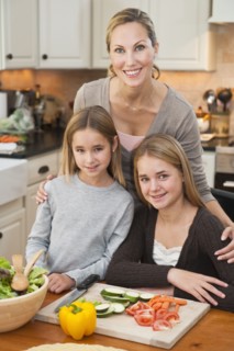 Mother and daughters making salad.