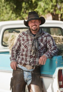 Cowboy leaning on truck.