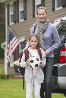 Mother and daughter holding soccer ball.