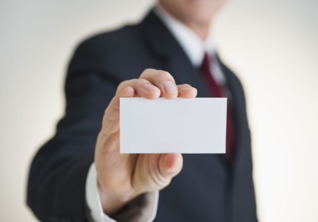 Businessman holding white card.