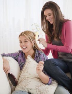Woman brushing friends hair. Photographer: Jamie Grill